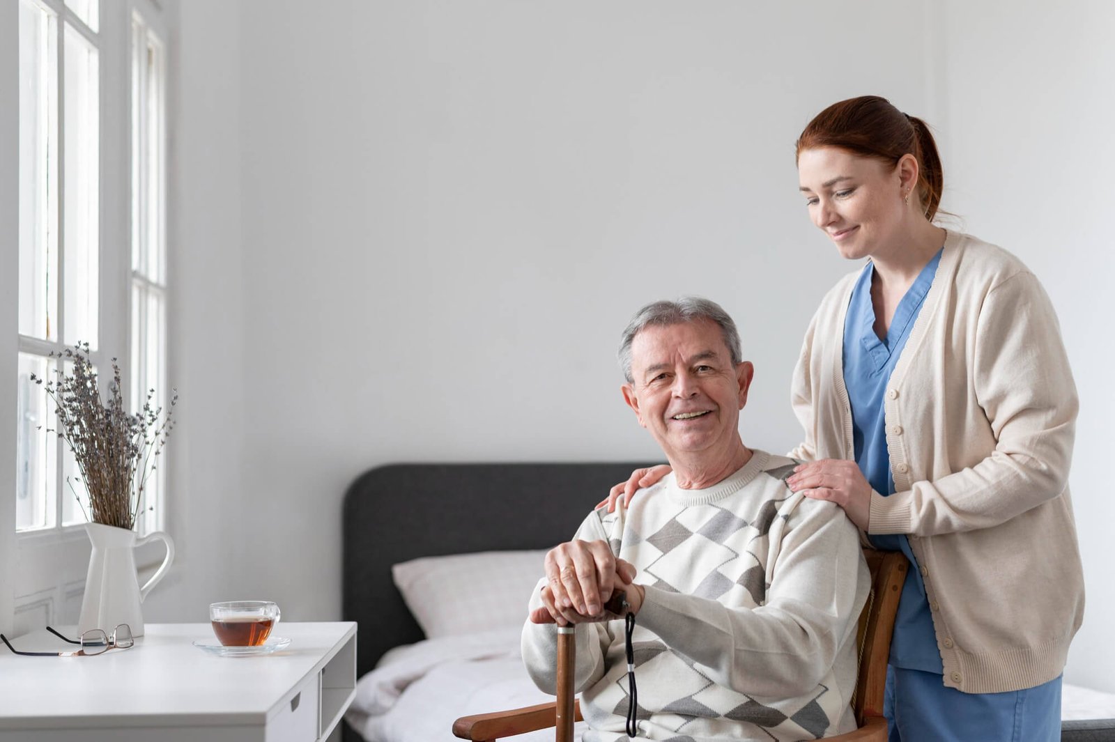 Hospice nurse sitting with an older patient at home