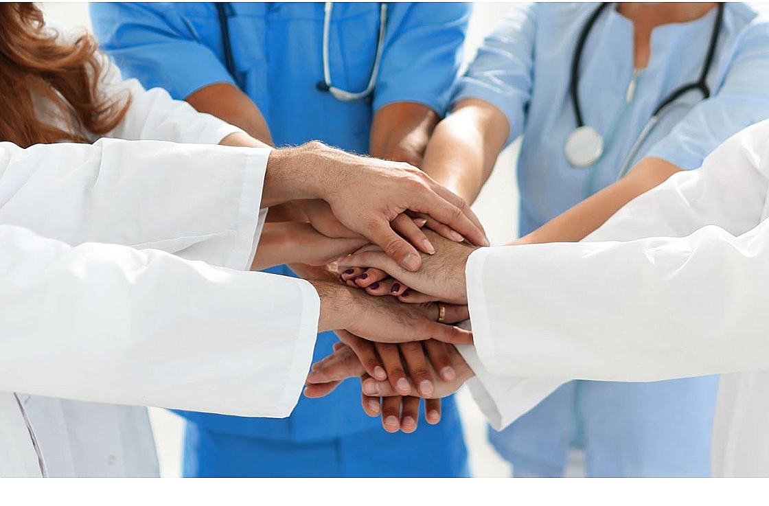 Hospice care team joining hands together